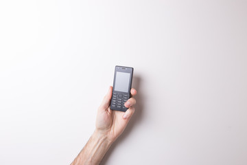 \hand , hand holds the old phone on white background