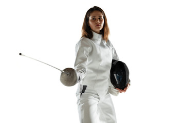 Champion. Teen girl in fencing costume with sword in hand isolated on white background. Young female model practicing and training in motion, action. Copyspace. Sport, youth, healthy lifestyle.