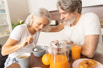 Happy husband looking at his eating wife