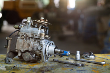 Fototapeta na wymiar Diesel injection pump on mechanic working table, mechanical maintenance and repair background