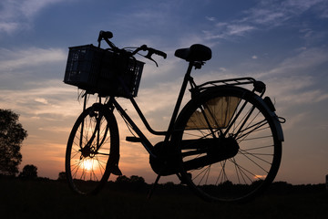 Fototapeta na wymiar silhouette of woman's bicycle at sunset