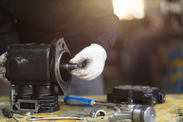 Mechanic man inspecion the air compressor pump, Mechanical maintenance and repair background