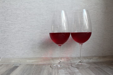 two glasses of red wine on wooden table