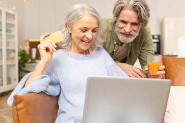Joyous mature married Caucasian couple buying online