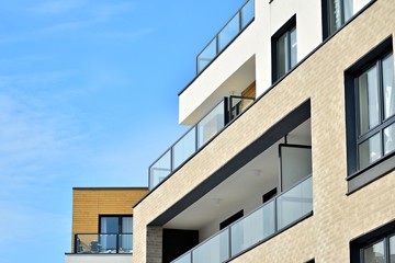 Contemporary residential building exterior in the daylight. Modern apartment buildings on a sunny day with a blue sky. Facade of a modern apartment building