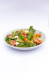 white deep plates with fresh salad ingredients mixed with sauce placed on isolated white background. A place for a menu, banner or advertisement