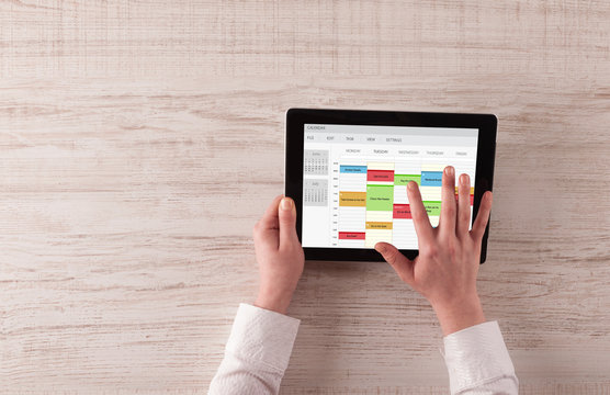 Hand holding tablet with timetable and calendar concept