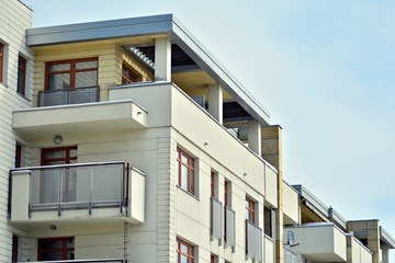 Contemporary residential building exterior in the daylight. Modern apartment buildings on a sunny day with a blue sky. Facade of a modern apartment building