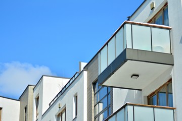 Contemporary residential building exterior in the daylight. Modern apartment buildings on a sunny day with a blue sky. Facade of a modern apartment building