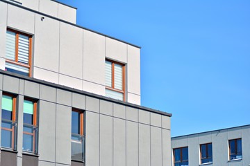 Contemporary residential building exterior in the daylight. Modern apartment buildings on a sunny day with a blue sky. Facade of a modern apartment building