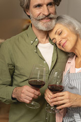Married couple holding glasses of red wine