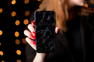Broken glass screen smartphone in hand of upset girl, white background.