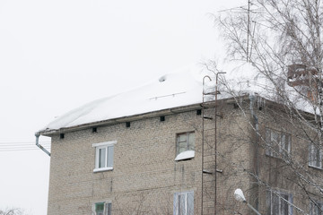 Snow and icicles hang from the roof