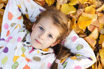 Portrait of a girl lying on the autumn leaf.