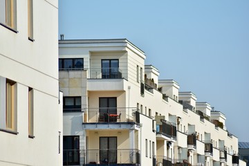 Contemporary residential building exterior in the daylight. Modern apartment buildings on a sunny day with a blue sky. Facade of a modern apartment building