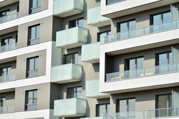 Contemporary residential building exterior in the daylight. Modern apartment buildings on a sunny day with a blue sky. Facade of a modern apartment building