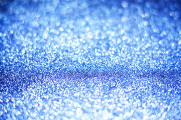 Bright festive background with sparkles and bokeh. Blue backdrop of celebration. New year or Christmas