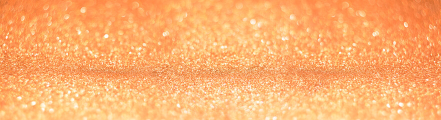 Bright festive background with sparkles and bokeh. Orange backdrop or banner of celebration. New year or Christmas