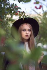 Attractive young woman enjoying her time outside in park in trees in background.