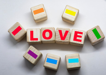 word love on wooden cubes with rainbow background
