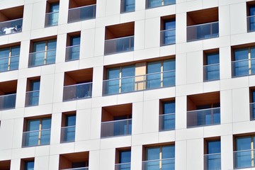 Contemporary residential building exterior in the daylight. Modern apartment buildings on a sunny day with a blue sky. Facade of a modern apartment building