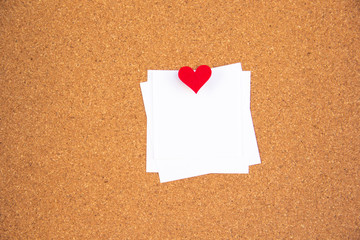 one red heart note paper on cork board