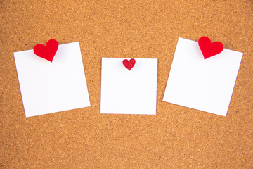 cork board with three red heart note