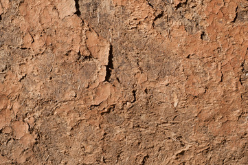 Adobe clay weathered wall of rural vintage country house closeup as clay background