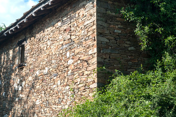 Old rural country stone house facade in sunny summer day