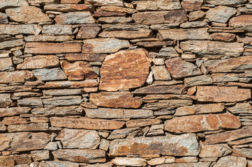 Old rough weathered grunge house stone wall closeup as stone background