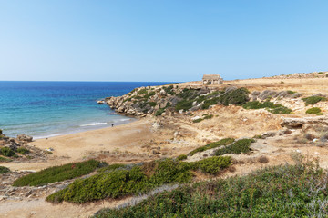 Fototapeta na wymiar Mediterranean Sea in Northern Cyprus. The ruins of an ancient building on the island. Summer seashore with transparent blue water. Seascape