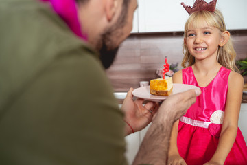 Happy little girl celebrating birthday with her father