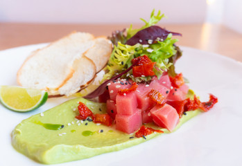 Fototapeta na wymiar tuna Tartar with avocado, lettuce, sun-dried tomatoes and bread chips