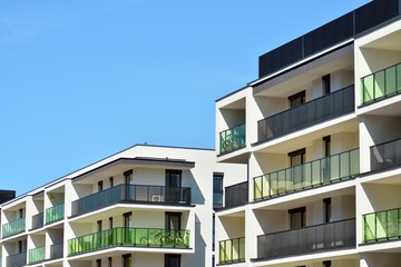 Contemporary residential building exterior in the daylight. Modern apartment buildings on a sunny day with a blue sky. Facade of a modern apartment building