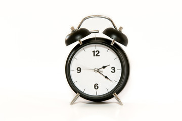 Vintage alarm clock with simple and minimalist design, isolated on white background. Secong hand moving, concept of time passing.