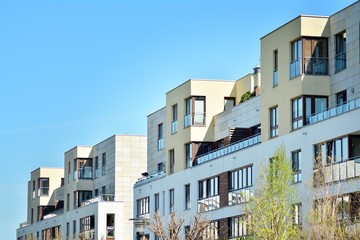 Contemporary residential building exterior in the daylight. Modern apartment buildings on a sunny day with a blue sky. Facade of a modern apartment building