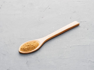 Spice masala in wooden spoon on gray concrete background. Indian cuisine, ayurveda, naturopathy concept