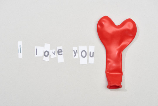 Top View Of I Love You Lettering With Red Balloon On Grey Background