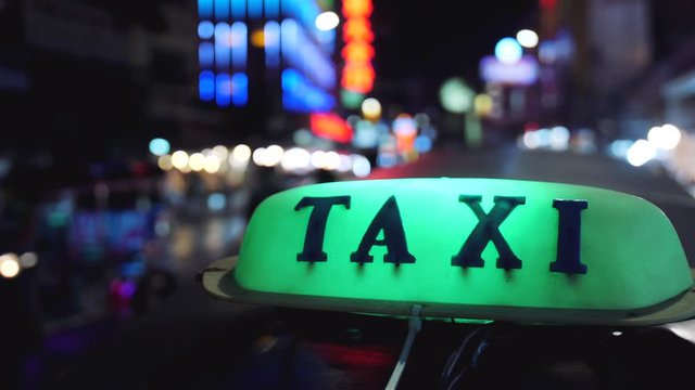 Close Up Of Taxi Sign With Night City Background. 4K.