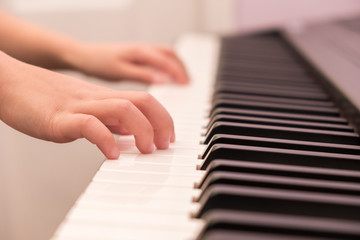 Fototapeta na wymiar Closeup of child's hands on piano keys