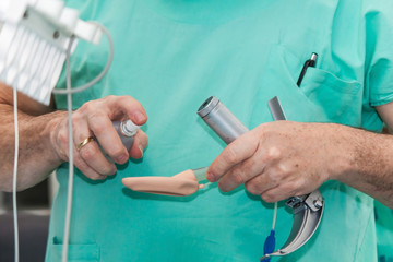 Anesthesiologist performing an endotracheal intubation to a female patient at the beginning of a...