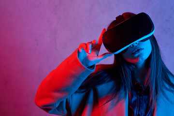 Young girl using virtual reality helmet while wearing a coat