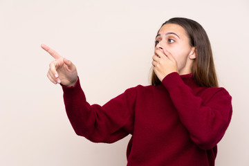 Teenager girl over isolated background pointing finger to the side