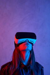 Young girl using virtual reality helmet while wearing a jacket