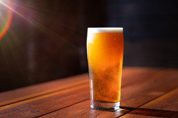 glass of craft beer in Sunlight on wooden table