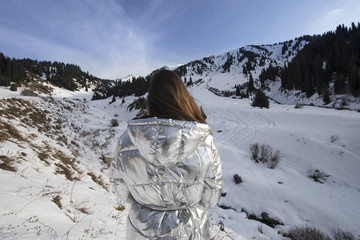 Fototapeta na wymiar girl in a white jacket high in the mountains in winter