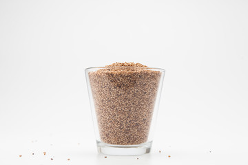Sesame seeds in glass cup on a white