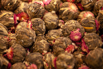 background of floral black tea, with rose petals, Black tea with flower petals and glass cups with tea. Bowl of black tea with flower petals and cups of tea, selective focus