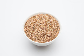 Toasted Sesame seeds in wooden spoon on white 