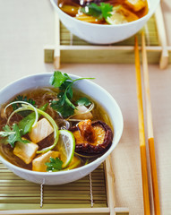 Asiatische Hühnersuppe mit Koriander und Shiitake Pilzen in einer Schüssel